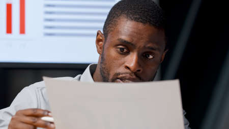 Young colleagues discussing the annual budget on the background of TV multimedia in the officeの写真素材