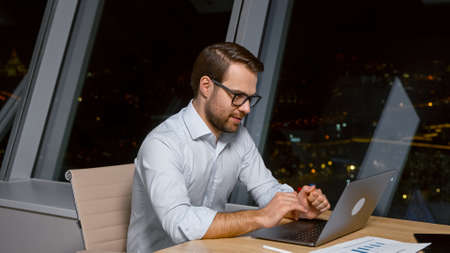 Young caucasian man professional using computer sitting at the desk in the workplaceの写真素材