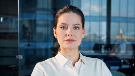 Serious successful woman listening to business partner via video call remotely in the workplaceの写真素材