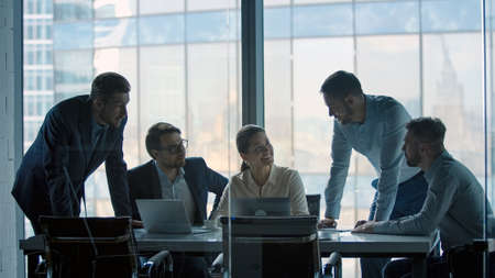 Smiling business people working as a team at a desk in a meeting room in office