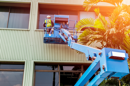 High-rise building maintenance engineers using cranesの写真素材