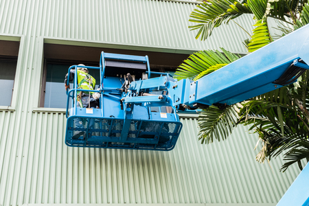High-rise building maintenance engineers using cranesの写真素材
