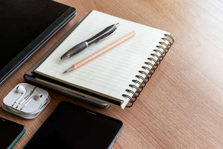 Laptop ,smartphone ,tablet with a pen ,notebook and earphones on the tableの写真素材