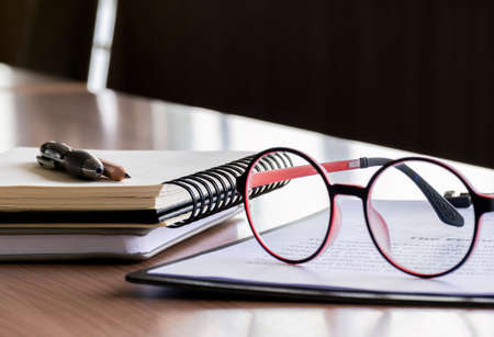 Glasses, pen, pencil, and notebooks in meeting roomの写真素材