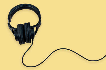 Black headphone isolated on yellow backgroundの写真素材