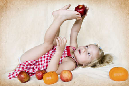 Cute toddler girl with fruitの写真素材