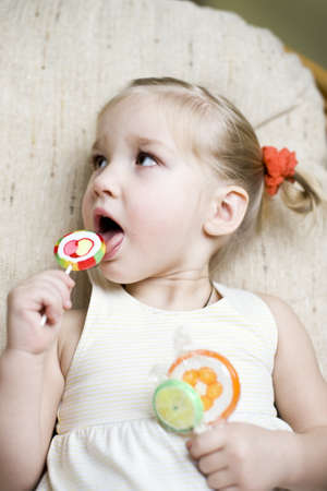 Cute toddler girl with candiesの写真素材