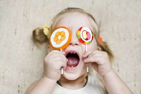 Funny toddler girl with candiesの写真素材