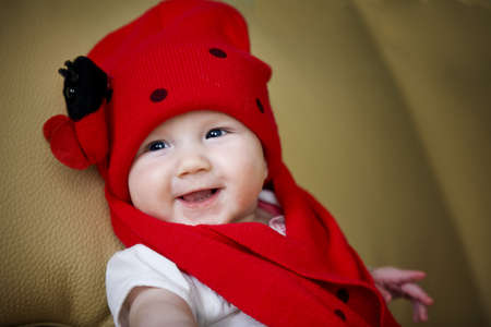 Smiling infant baby girl in the lady bug hatの写真素材