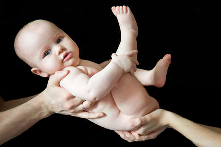 newborn baby naked on parents hands