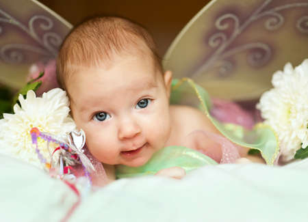 Newborn in fairy costume with wings smiling