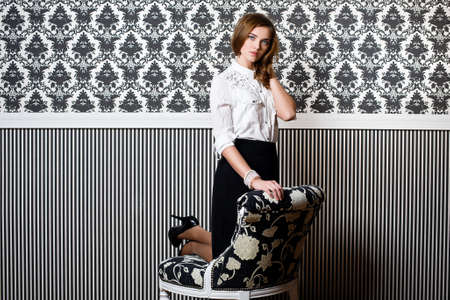 Pretty young woman in black and white clothes near black and white wallの写真素材