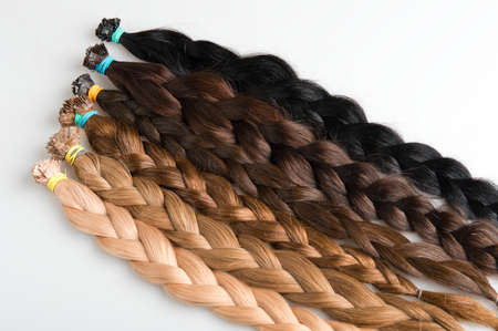 Plaits made of faux hair for beauty salolon different colors and structure  Blond, red and brunette on gray backgroundの写真素材