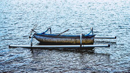 Small fishing boat on the beach in cloudy weatherの写真素材