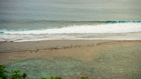 Beautiful views of the soft waves at sunset on the beach from the top of the cliffの写真素材