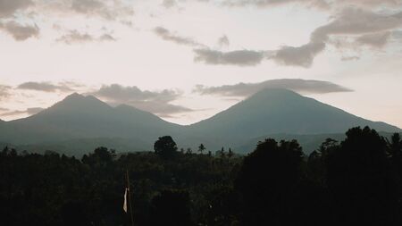 Silhouette of two mountains at sunrise