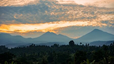 Beautiful view of the sun sky rising behind the mountainの写真素材