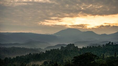 Beautiful view of the sun sky rising behind the mountainの写真素材