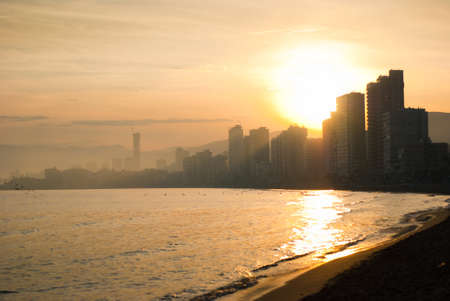 The sun sets behind the coastal home の写真素材