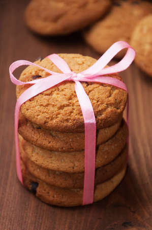 oatmeal cookies tied with pink ribbon on wooden tableの写真素材