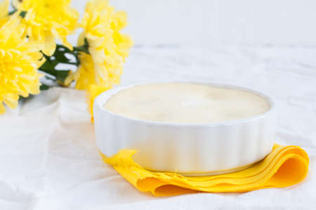 Cheese cake and a bouquet of yellow flowers on the table