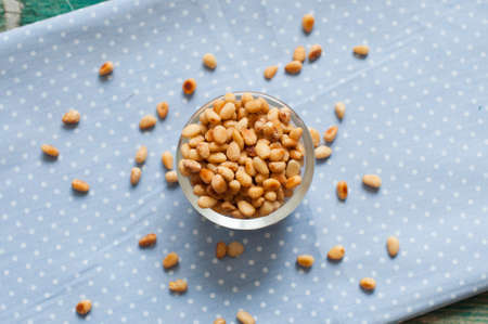 Roasted pine nuts on a background of blue napkin, top viewの写真素材