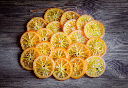 Sliced candied oranges on wooden background, shot from aboveの写真素材