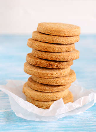 A stack of round shortbread biscuits on an old wooden table