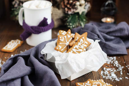 Christmas cookies in box and hot chocolate on wooden table