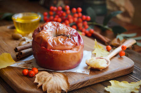 Baked apple with honey on wooden cutting boardの写真素材