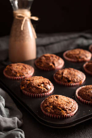 Several muffins in baking mold and cocoa drink with chia seeds. Low key.の写真素材