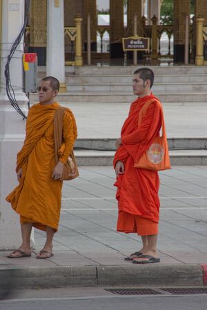 two monks waiting for the bus in Bangkok, Thailandのeditorial素材