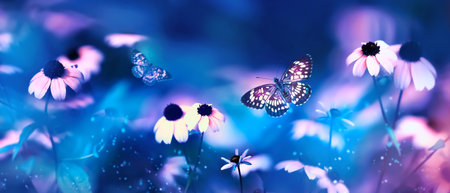 Tropical butterflies and pink bright summer flowers on a background of blue foliage in a fairy garden. macro artistic image. banner format.の写真素材