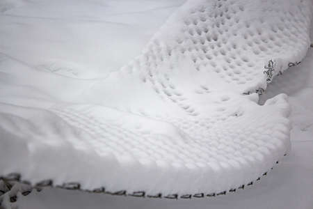 Mesh fence under a thick layer of snow after snowstormの写真素材