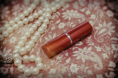 Women's lipstick, a necklace on fabric with Oriental ornaments. Vintageの写真素材