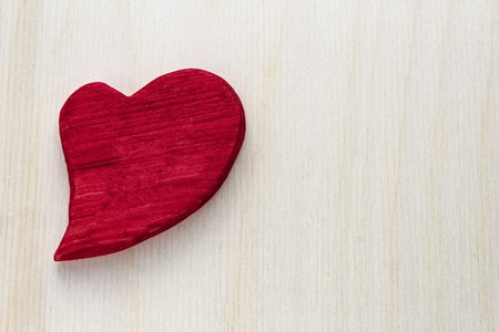 Wooden red heart on wooden background.の写真素材