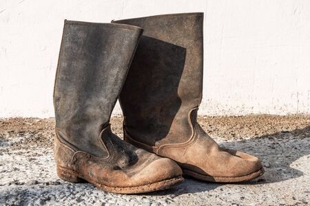 Old worn dirty boots. Shabby torn shoesの写真素材