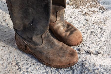 Old worn muddy boots. Old ragged shoes