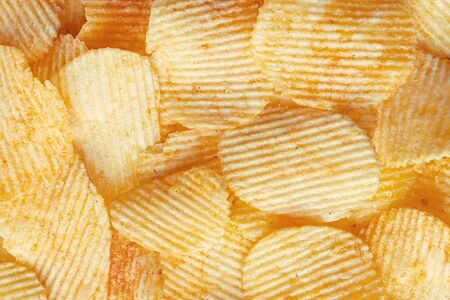 Potato fluted chips close-up. Background of corrugated chips top viewの写真素材