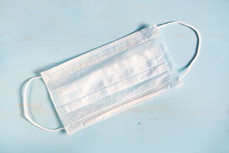 Medical mask on a blue wooden background. Protective maskの写真素材