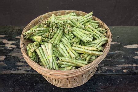 Natural tobacco is wrapped in palm leaves. There are a lot of roll-up cigarettes in the tableware