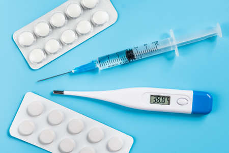 Syringe for injection, pills, electronic thermometer with a temperature of 38.8.