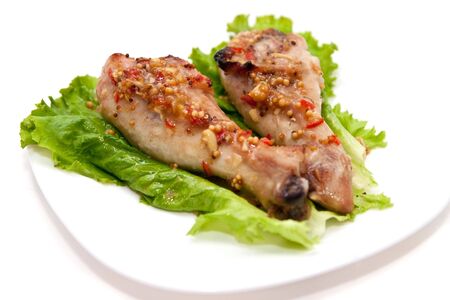 Grilled chicken legs with honey and french mustard at white plate and fresh lettuce. Isolated on white.の写真素材