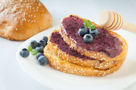 Healthy breakfast. Homemade bread with sesame spread with cream honey and blueberries and mint