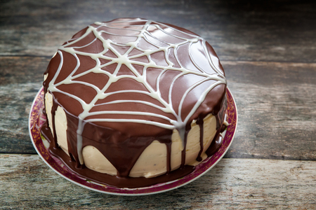 Chocolate cake with spider web Halloween decoration on wood backgroundの写真素材