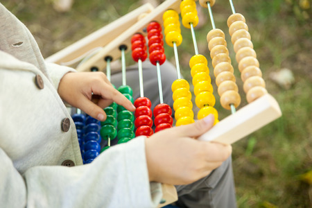 Schoolboy holding abacus. Back to school outdoorsの写真素材