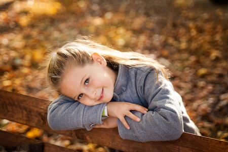 Little smiling girl in the autumn parkの写真素材