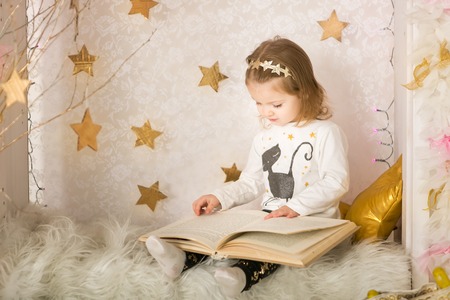 Cute little girl with a book. Christmas timeの写真素材