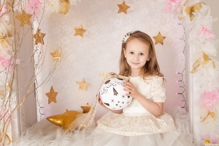 Cute smiling blondy girl with a big Christmas ball. Christmas timeの写真素材