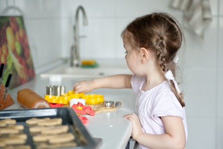 Little girl cutting out christmas cookiesの写真素材